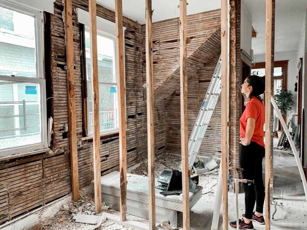 Homeowner inspecting stripped interior walls during a home renovation affected by an Oklahoma mechanic's lien dispute